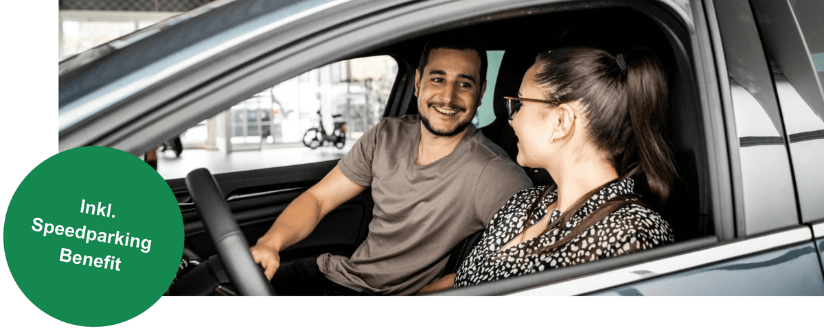 Ein Mann und eine Frau sitzen im Auto und lächeln