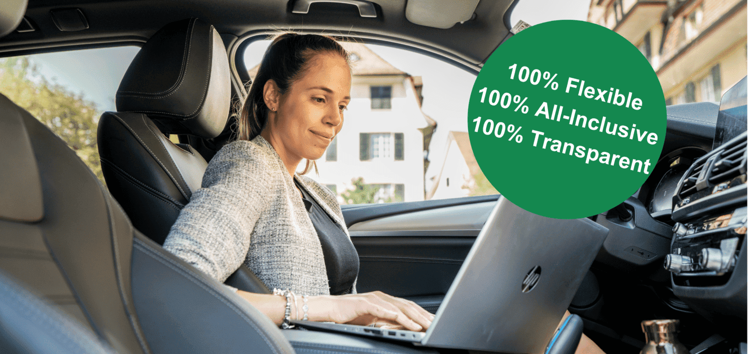 Blonde Frau sitzt in Auto und schaut in ihren Laptop